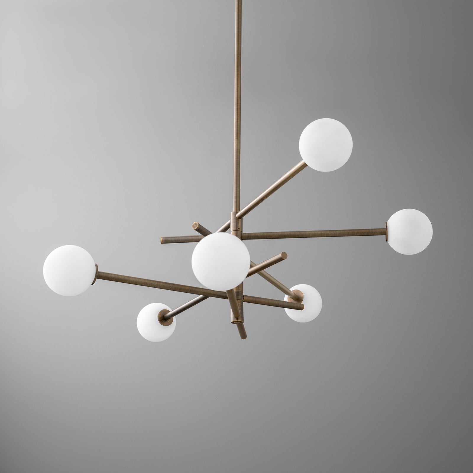 Antique brass chandelier with six white globe lights on minimalist intersecting rods. - CHANDELIER MODEL NO. 8576