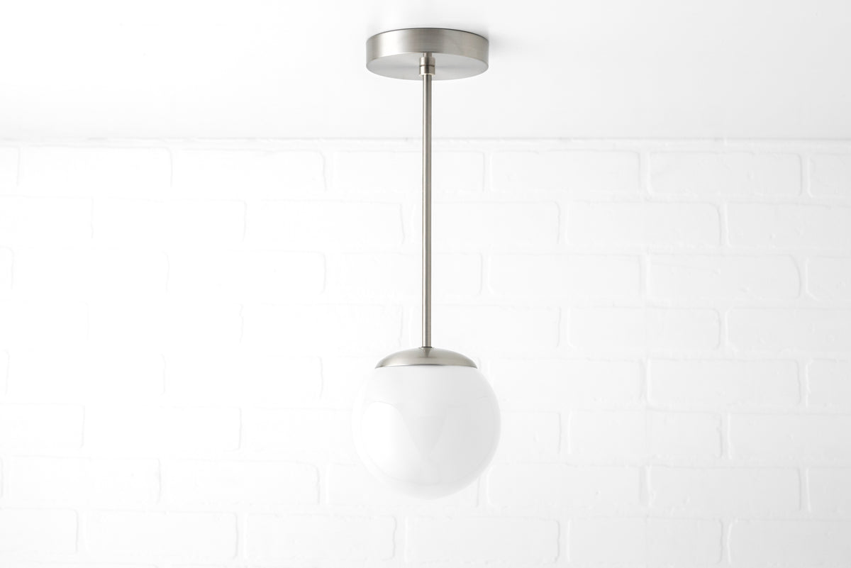 Mid-century modern pendant light with brushed nickel finish and white frosted glass globe shade. - PENDANT MODEL NO. 7056