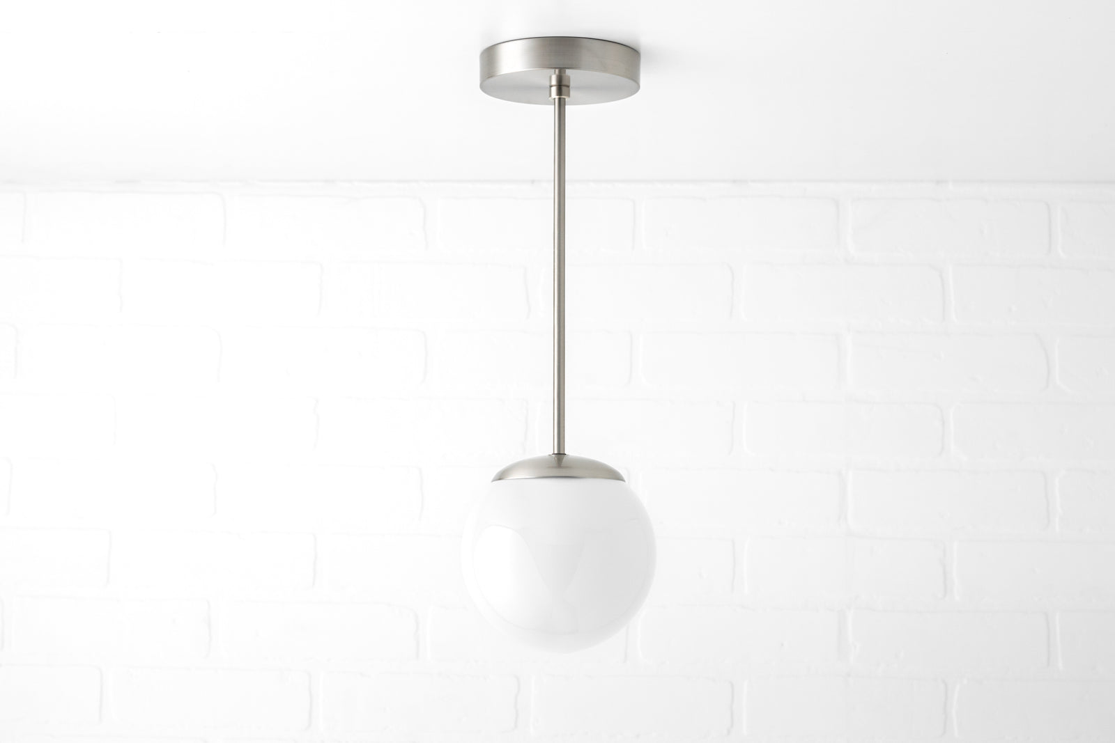 Mid-century modern pendant light with brushed nickel finish and white frosted glass globe shade. - PENDANT MODEL NO. 7056