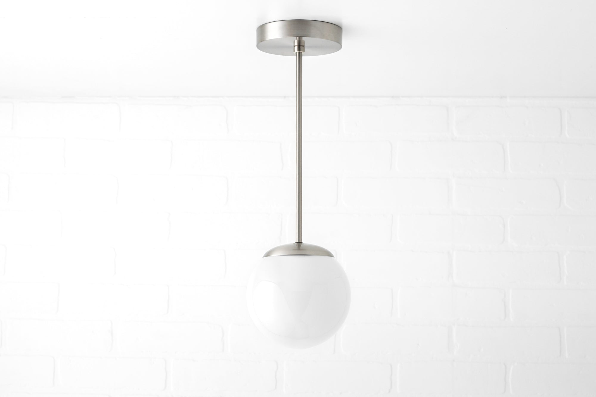 Mid-century modern pendant light with brushed nickel finish and white frosted glass globe shade. - PENDANT MODEL NO. 7056