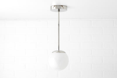 Mid-century modern pendant light with a white glass globe and chrome fixture suspended by a slim rod. - PENDANT MODEL NO. 7056
