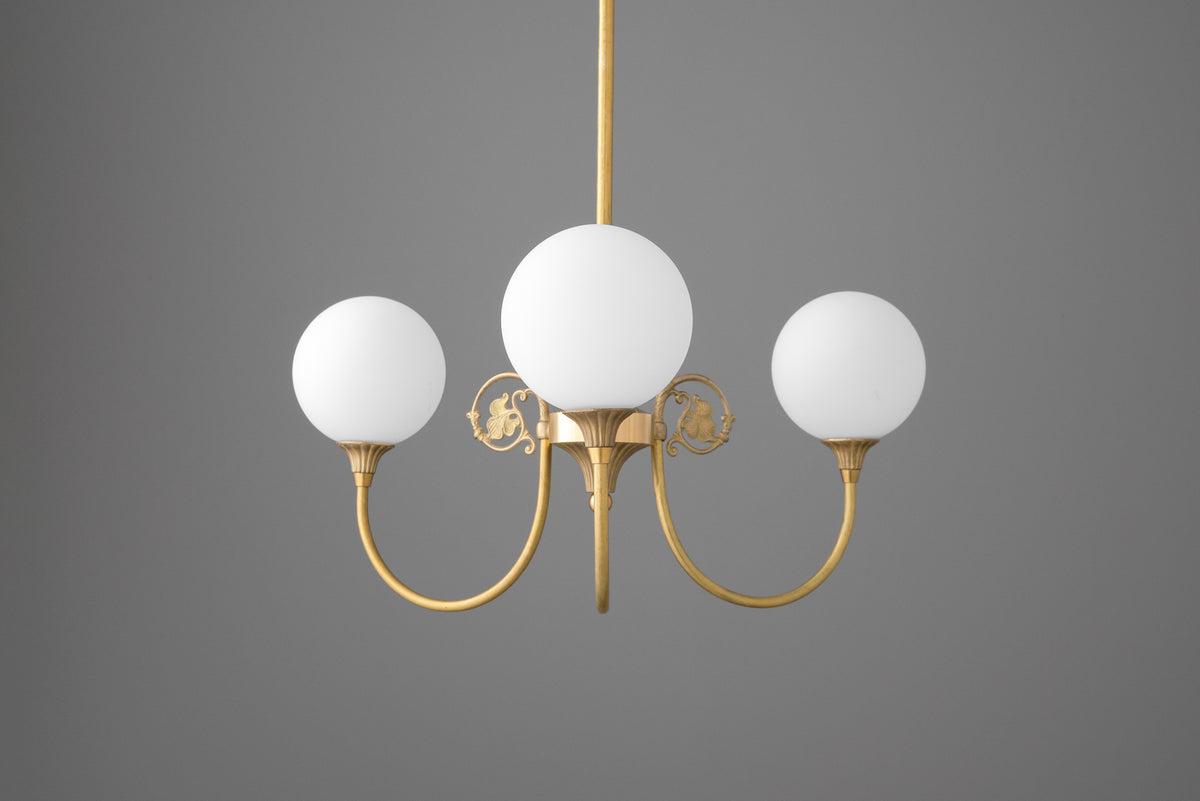 Three-light chandelier in Raw or Sealed Brass with curved arms, scrolled leaf ornaments and opal glass globe shades. - CHANDELIER MODEL NO. 0835