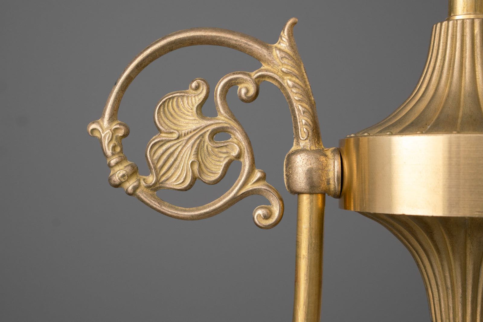 Close-up of a scrolled leaf arm ornament beside the fluted center body of the chandelier in Raw or Sealed Brass. - CHANDELIER MODEL NO. 0835