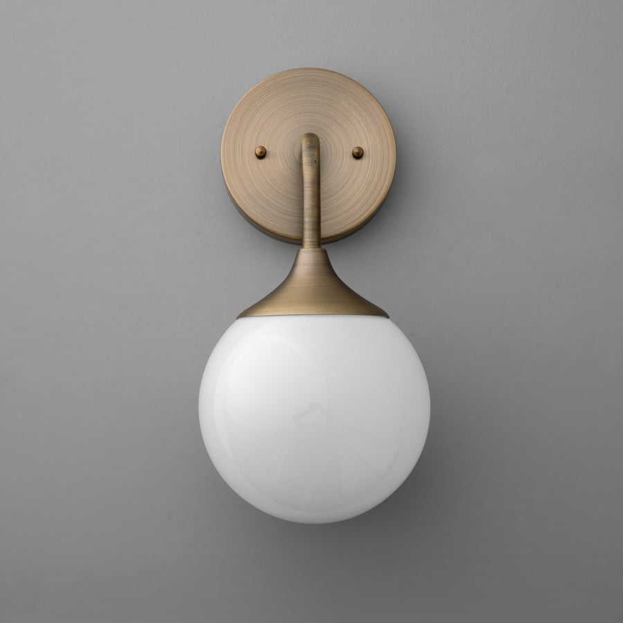 Antique brass wall sconce with a round white glass globe shade on gray background. - SCONCE MODEL NO. 1752