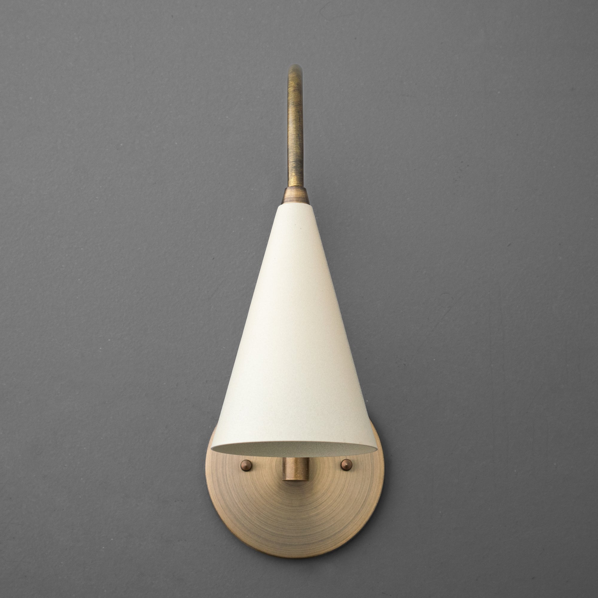 Antique brass wall sconce with conical cream shade and round backplate on gray background. - SCONCE MODEL NO. 1309