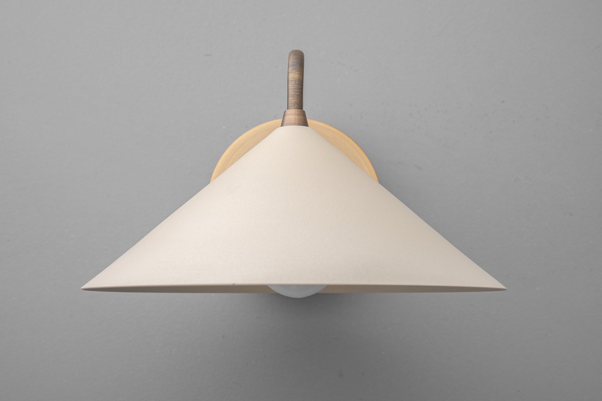 Wall sconce with wide cream fabric shade and antique brass mount against gray background. - SCONCE MODEL NO. 6528