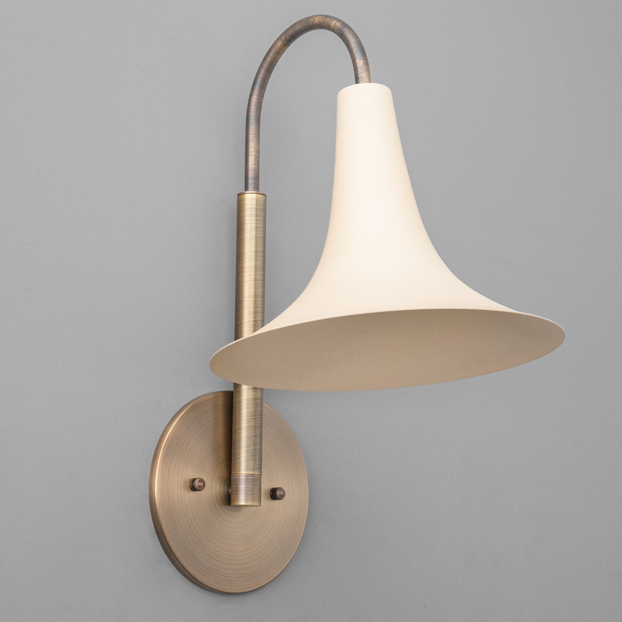 Antique brass wall sconce with curved arm and cream flared metal shade. - SCONCE MODEL NO. 3851