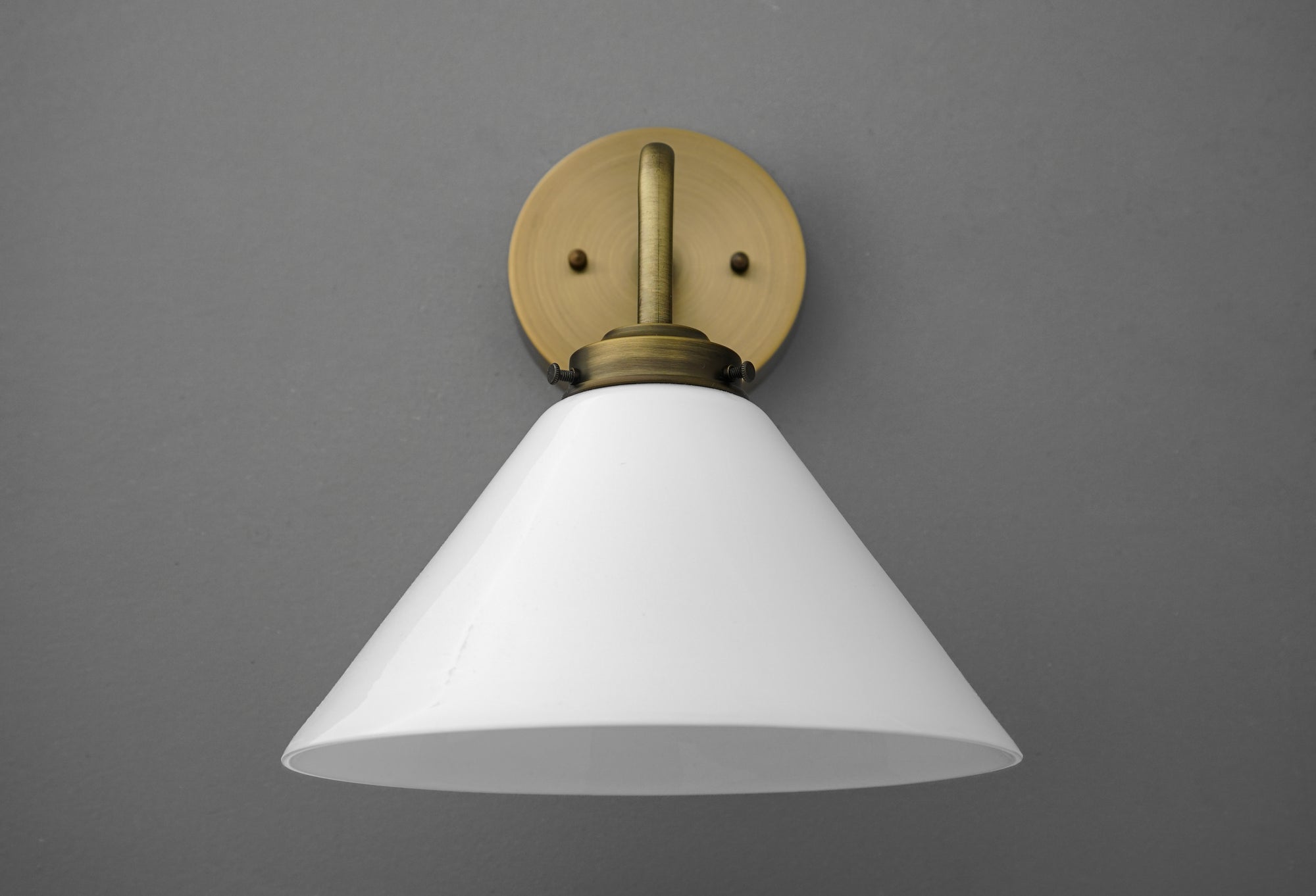 Wall sconce with white conical shade and antique brass finish mounting plate and arm. - SCONCE MODEL NO. 8751