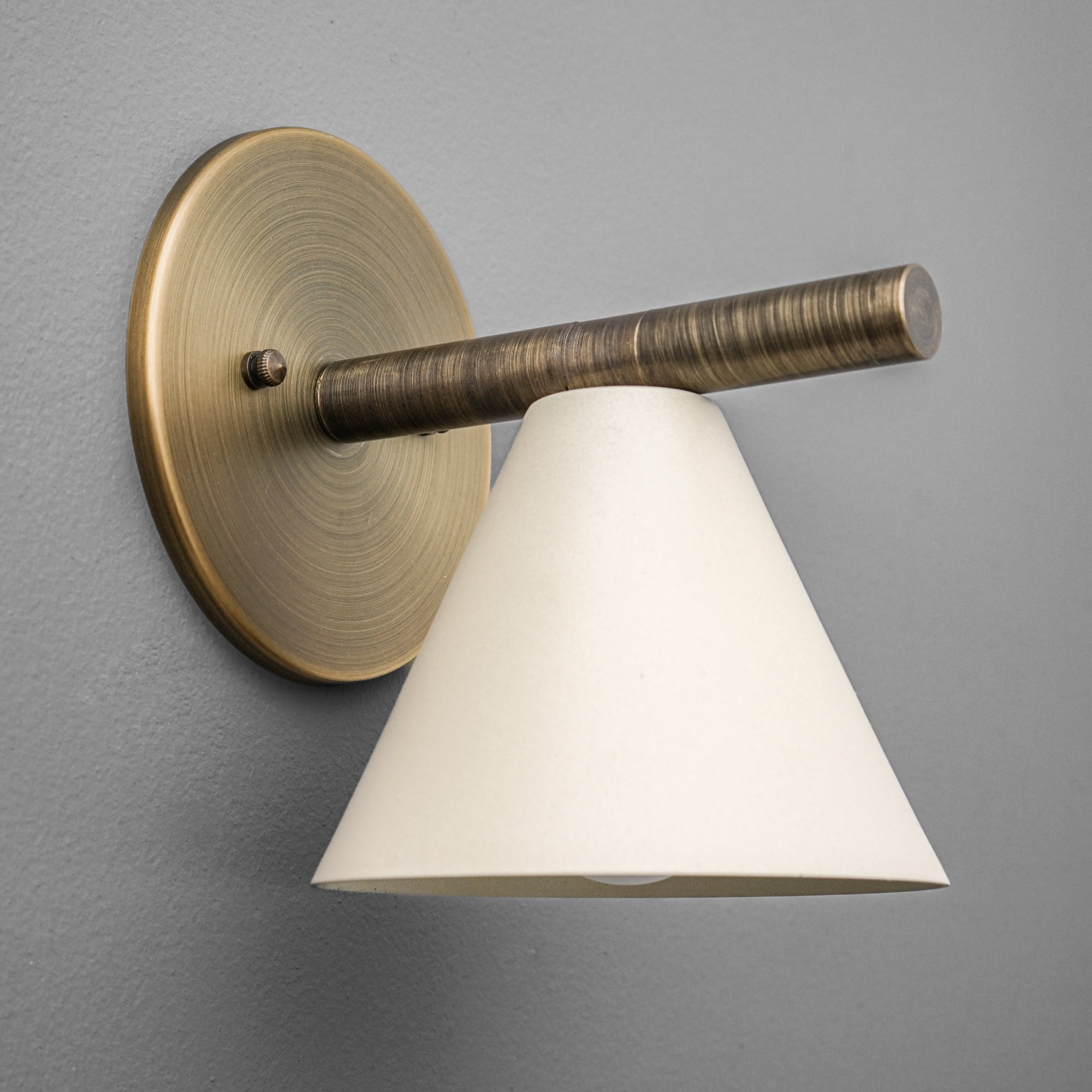 Antique brass wall sconce with tapered cream fabric shade and cylindrical arm. - SCONCE MODEL NO. 5075