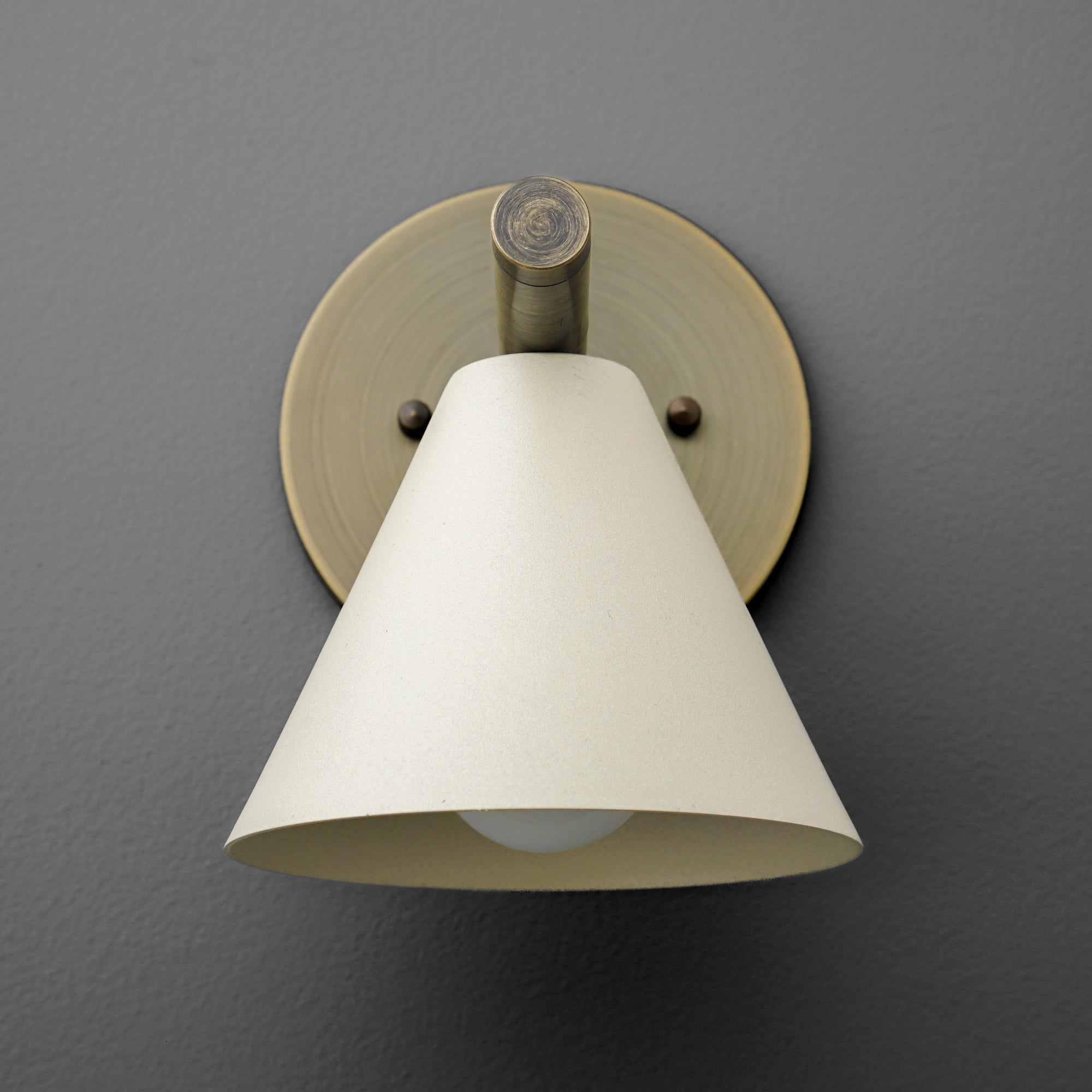 Antique brass wall sconce with cream cone-shaped shade mounted on round backplate. - SCONCE MODEL NO. 5075