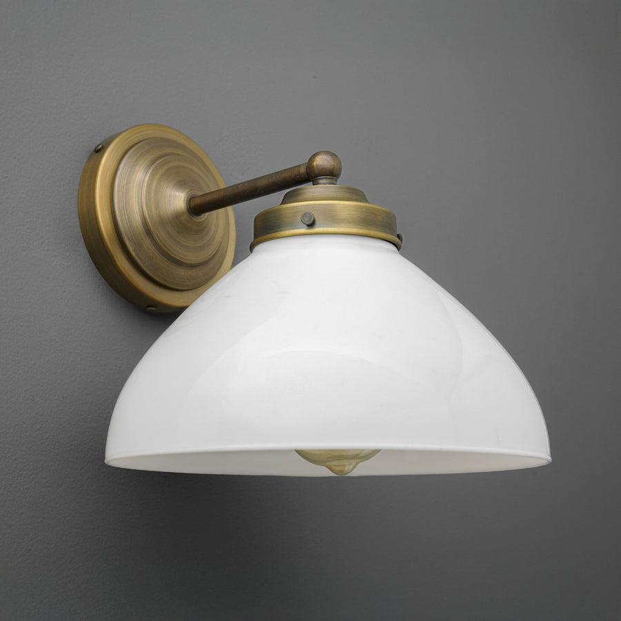Wall-mounted sconce with antique brass finish and white glass dome shade on gray background. - SCONCE MODEL NO. 9835