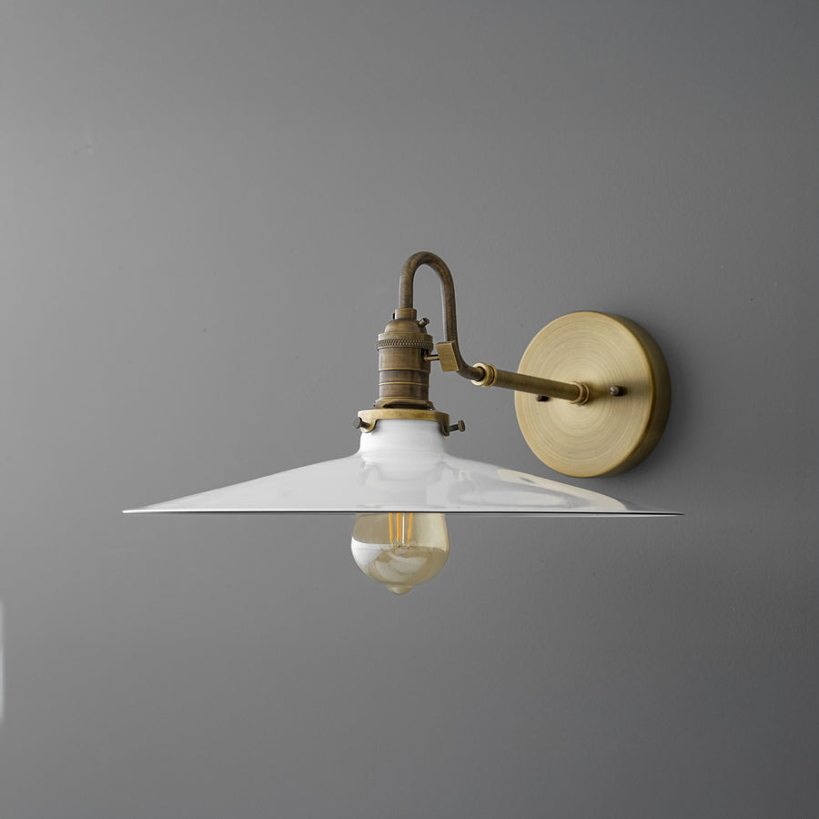 Brass wall sconce with wide white metal shade and exposed Edison bulb on gray wall. - SCONCE MODEL NO. 5562