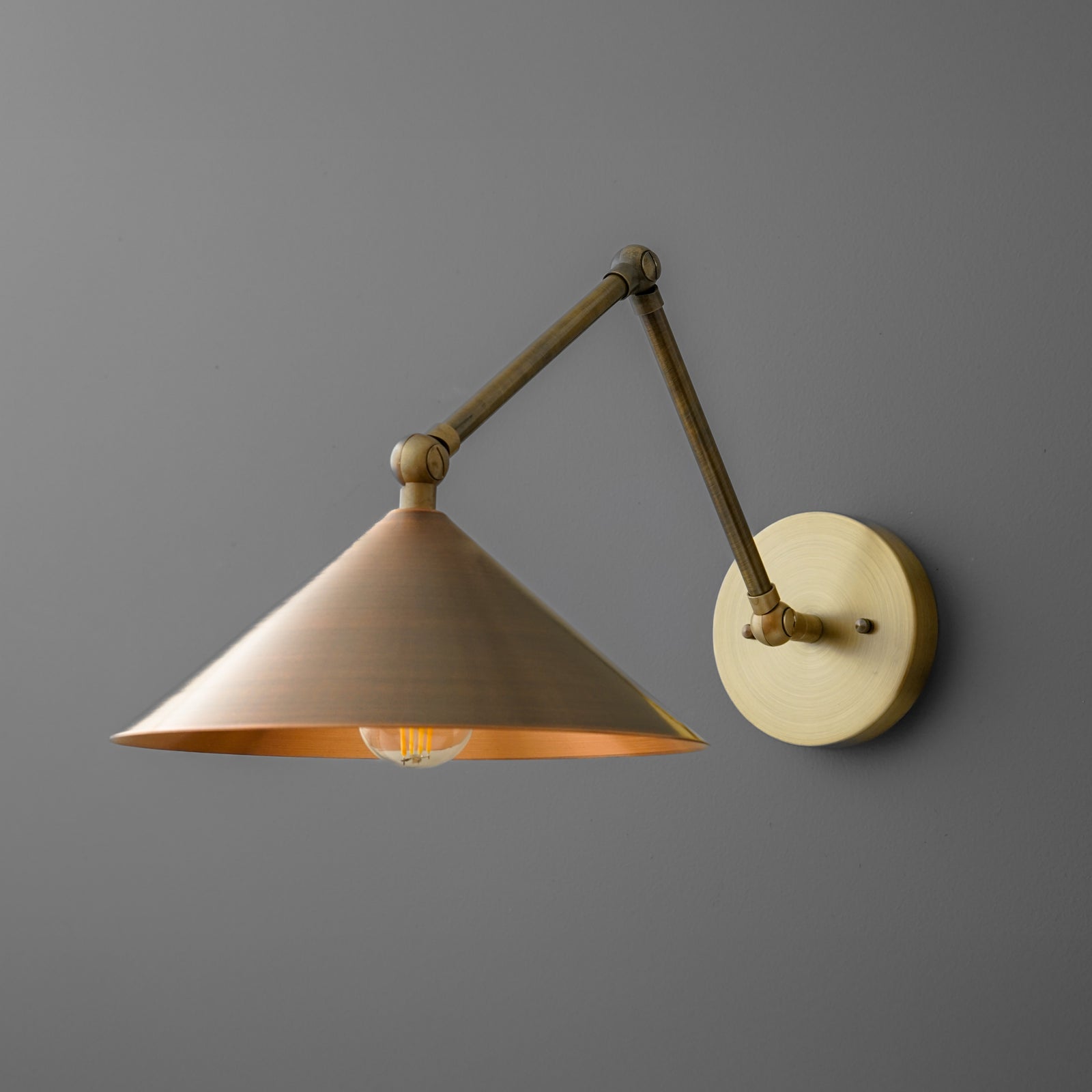 Brass wall sconce with adjustable arm and conical shade, warm metallic finish. - SCONCE MODEL NO. 6414