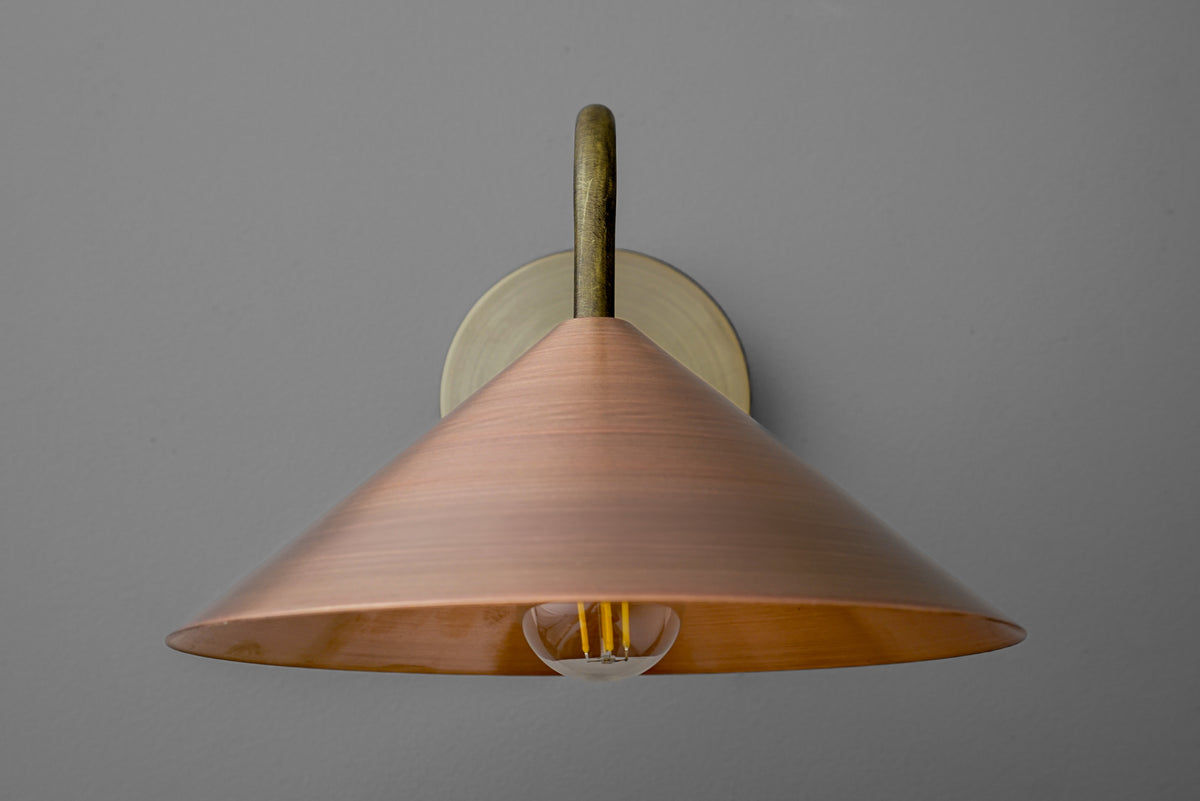 Wall sconce with wide conical copper shade and antique brass mounting on gray background. - SCONCE MODEL NO. 7574