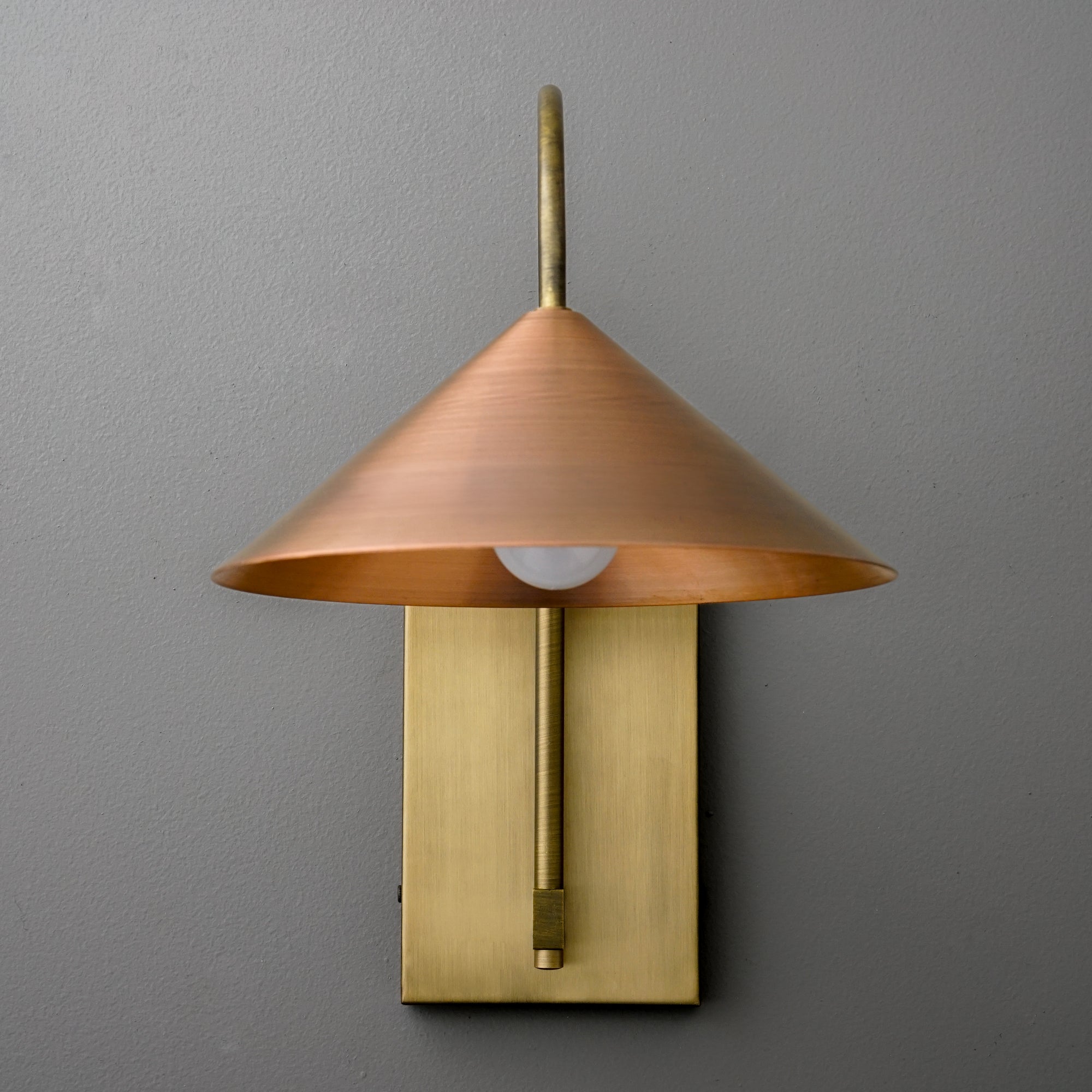 Wall sconce with raw brass rectangular base and conical copper lampshade over exposed bulb. - SCONCE MODEL NO. 2096