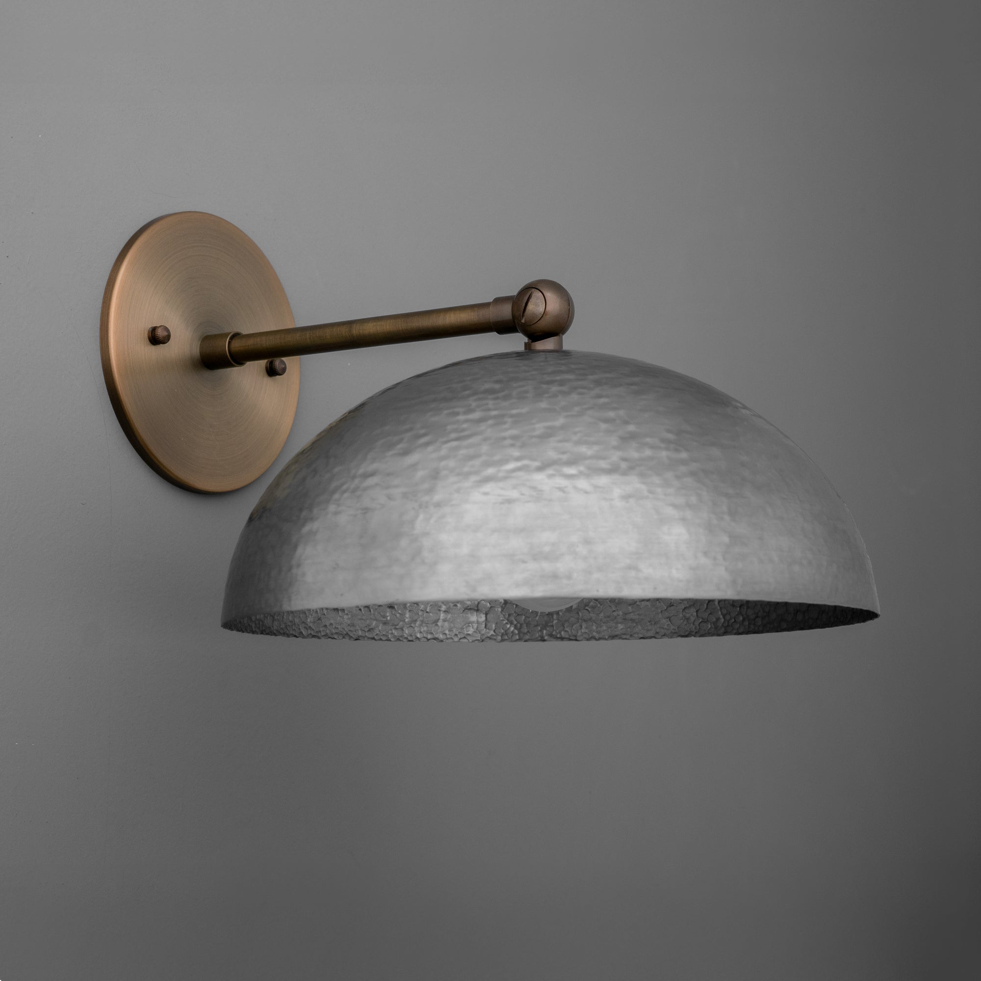 Wall sconce with textured half-dome steel shade and antique brass arm and round wall plate. - SCONCE MODEL NO. 3164
