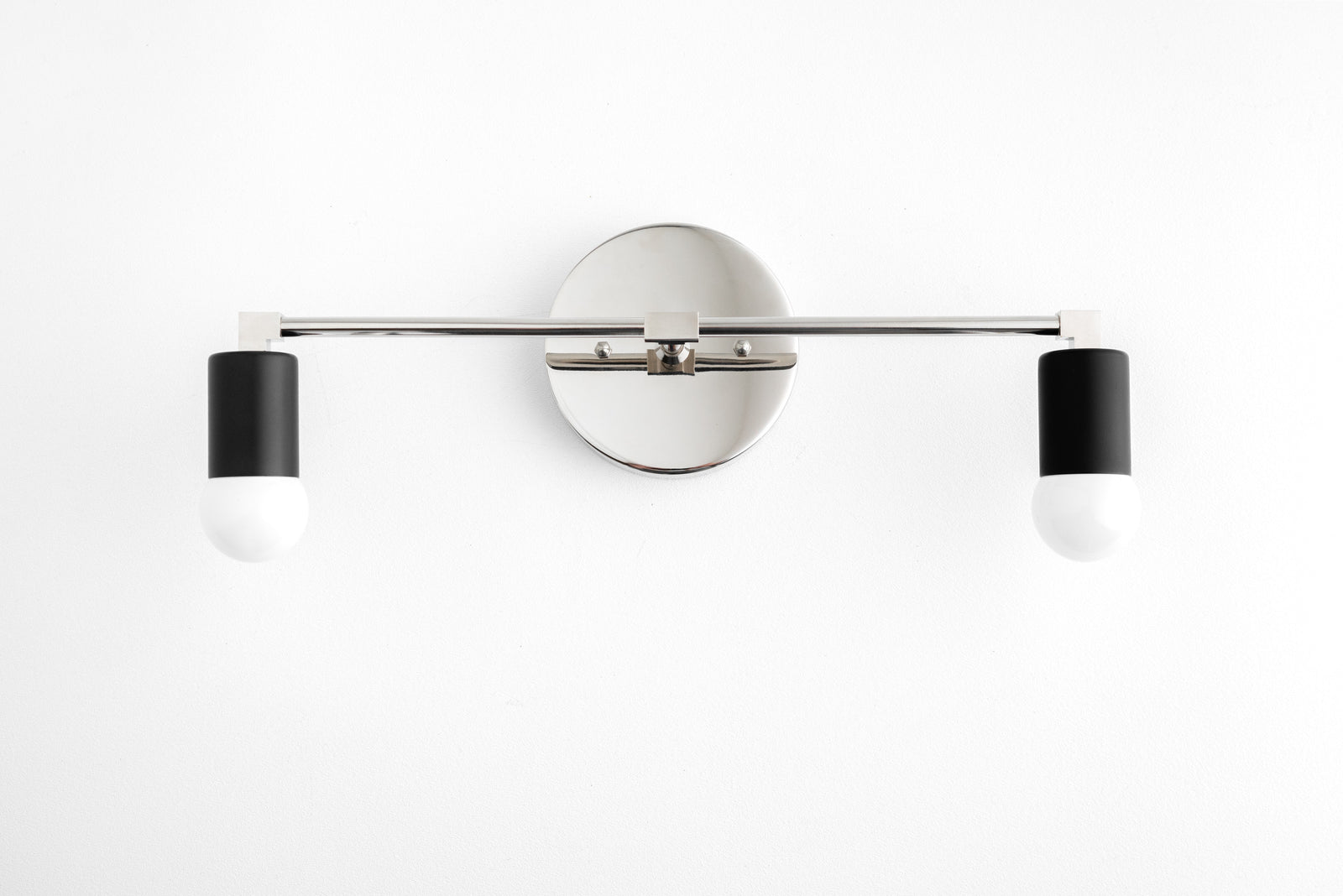 Two-light vanity light in Polished Nickel/Black, with a Polished Nickel wall plate and bar and Black sockets. - VANITY LIGHT MODEL NO. 8412