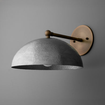 Wall sconce with aged steel dome shade and antique brass round wall plate on gray background. - SCONCE MODEL NO. 3164