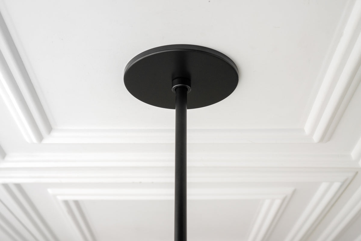 Black metal ceiling mount and rod extending downward from a white ceiling with decorative molding. - CHANDELIER MODEL NO. 0678