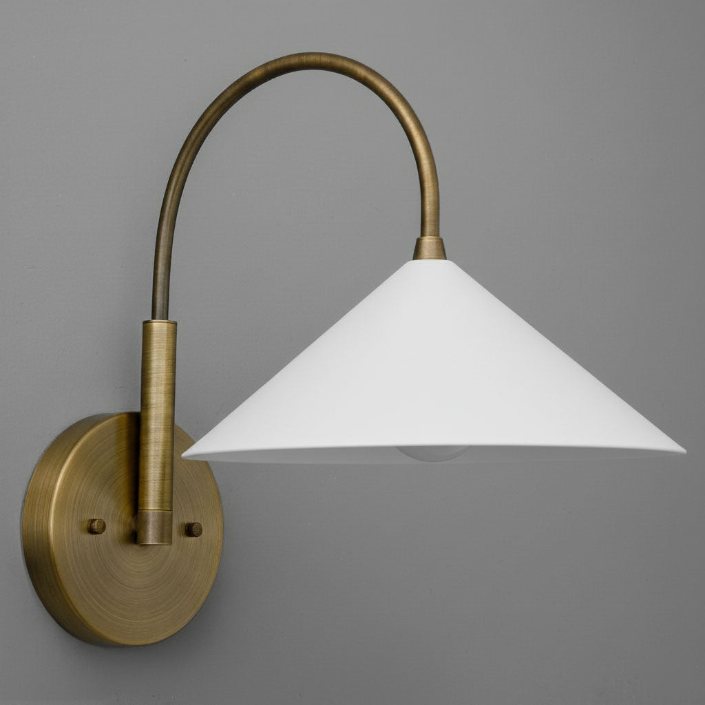 Antique brass wall sconce with curved arm and white conical shade against gray background. - Sconce Model No. 1583