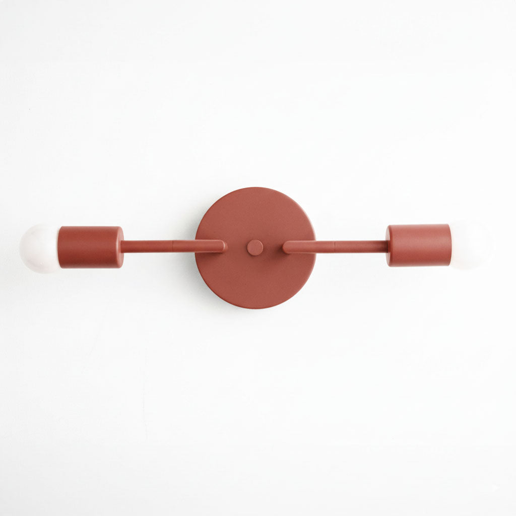 Mid-century modern brick red two-bulb vanity light with cylindrical sockets and round wall mount. - VANITY LIGHT MODEL NO. 1938