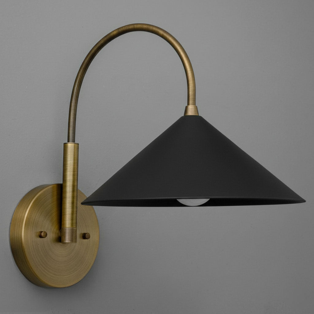 Antique brass wall sconce with curved arm and matte black conical shade. - Sconce Model No. 1583
