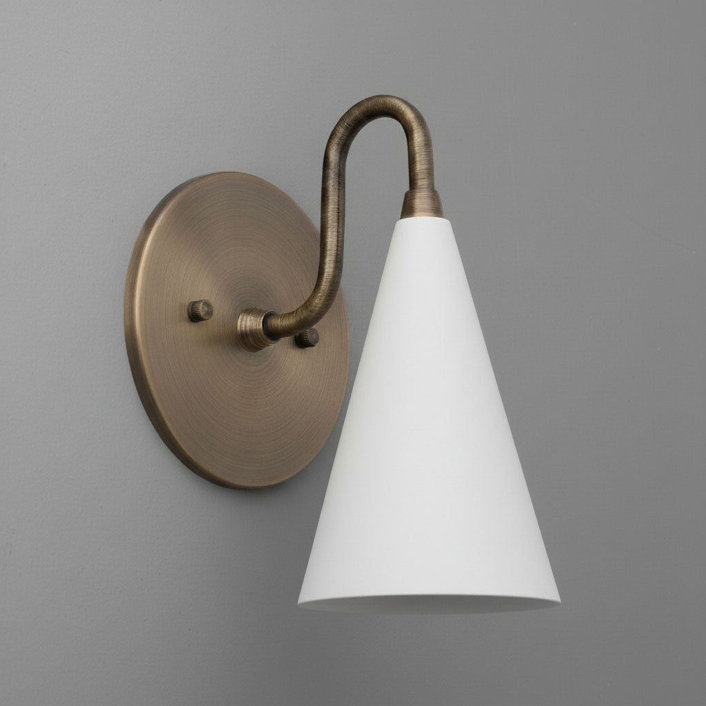 Antique brass wall sconce with a conical white shade and curved arm mounted on round base. - Sconce Model No. 2900
