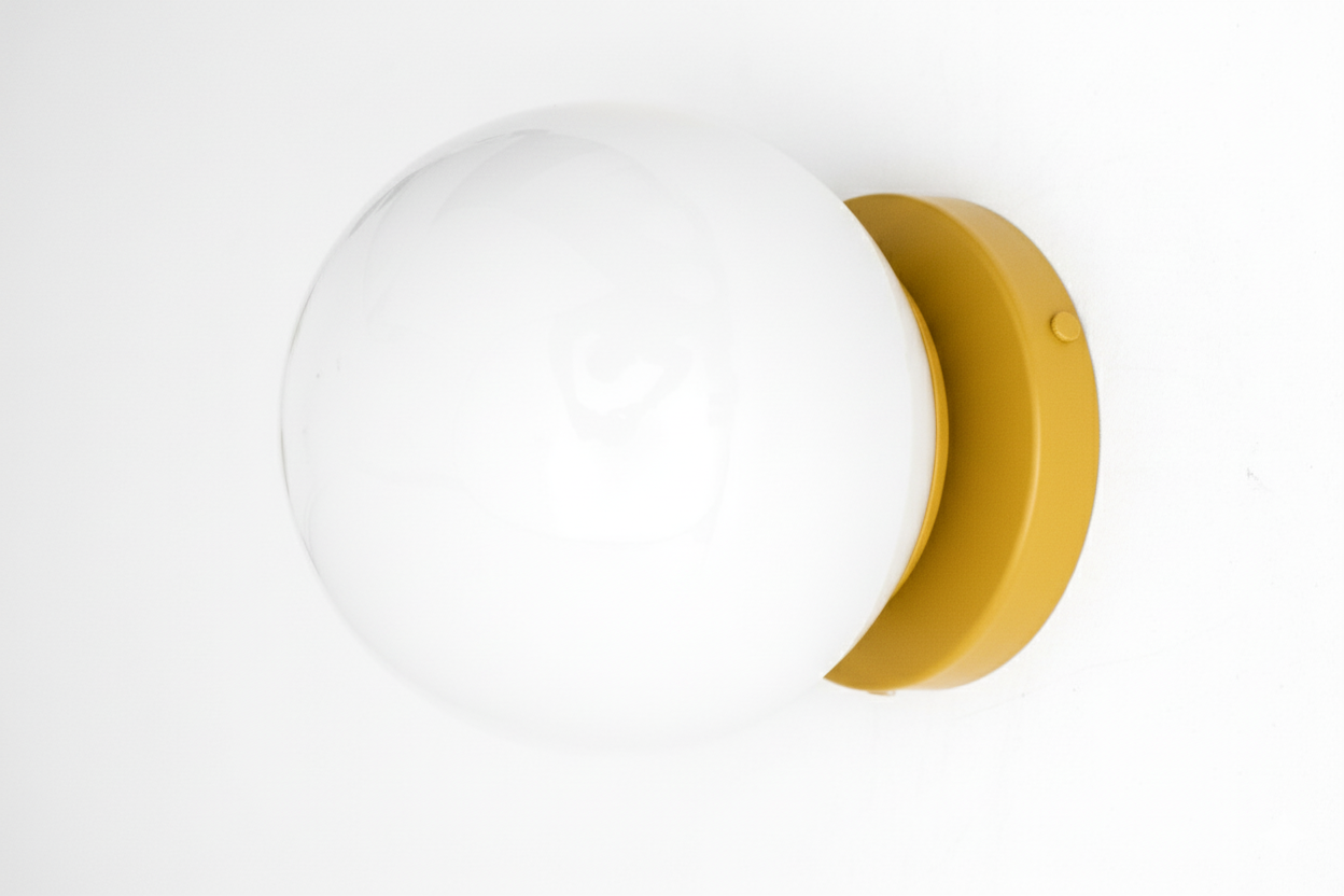 Mid-century modern wall sconce with white globe and mustard yellow flush mount base. - SCONCE MODEL NO. 3825
