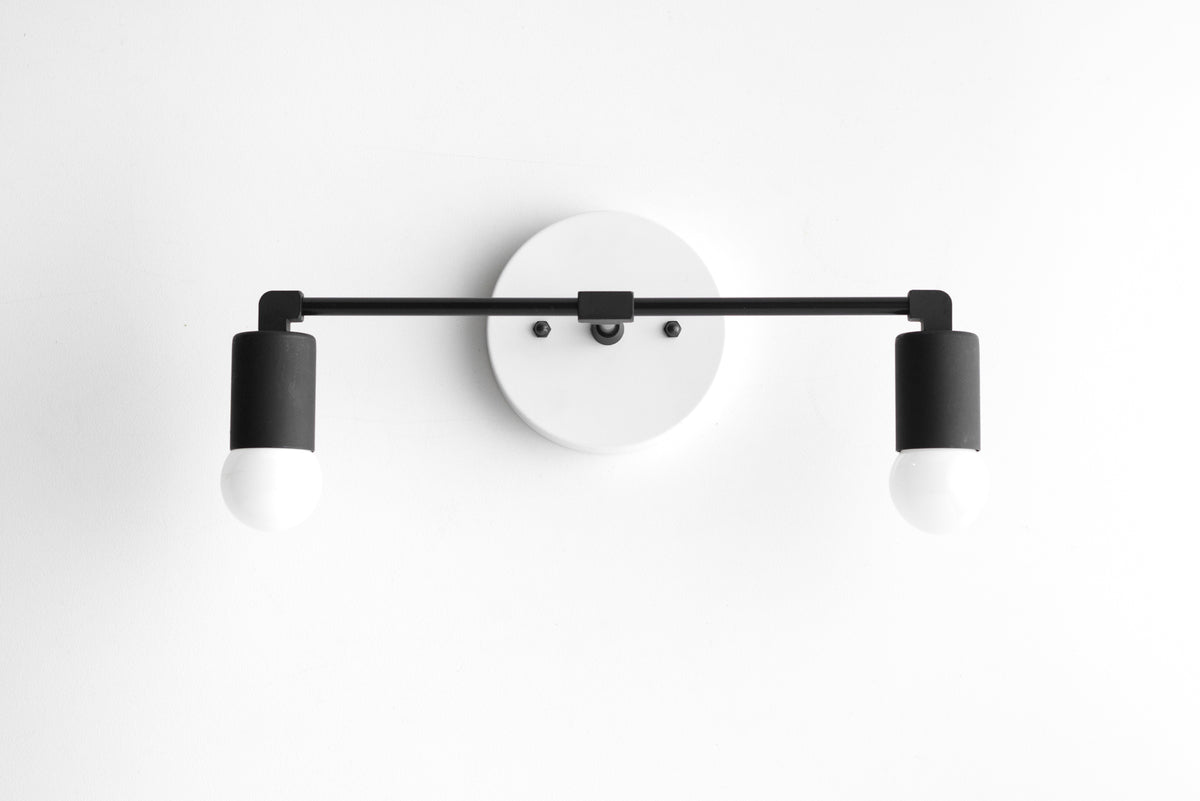 Two-light vanity light in White/Black, with a White round wall plate and a Black bar and sockets. - VANITY LIGHT MODEL NO. 8412