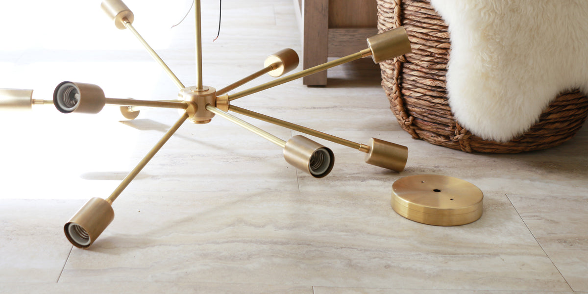 Brass sputnik chandelier arms and canopy on a stone floor
