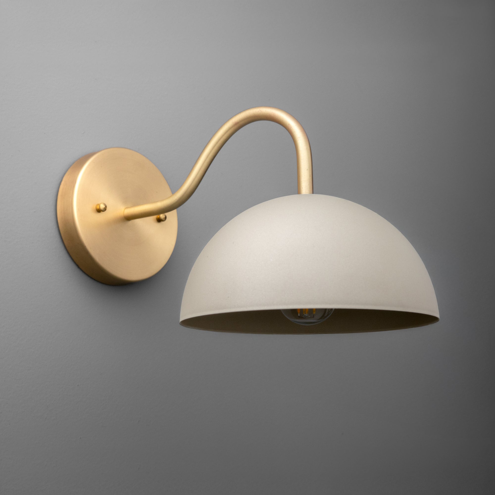 Brushed brass sconce with curved arm and large matte white dome shade, single bulb fixture. - SCONCE MODEL NO. 6678