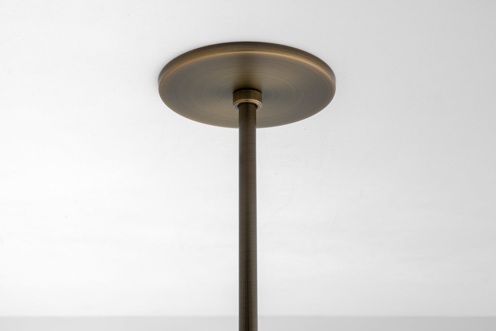 Antique brass ceiling pendant mounting plate with matching rod against white ceiling background. - PENDANT MODEL N0. 6780