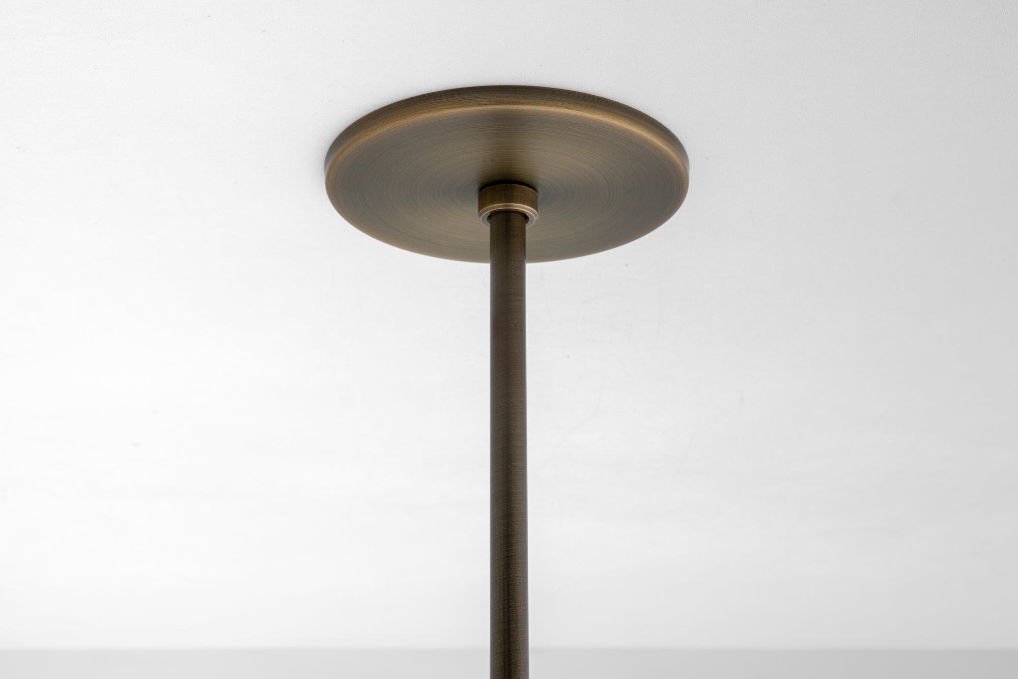 Antique brass ceiling pendant mounting plate with matching rod against white ceiling background. - PENDANT MODEL N0. 6780