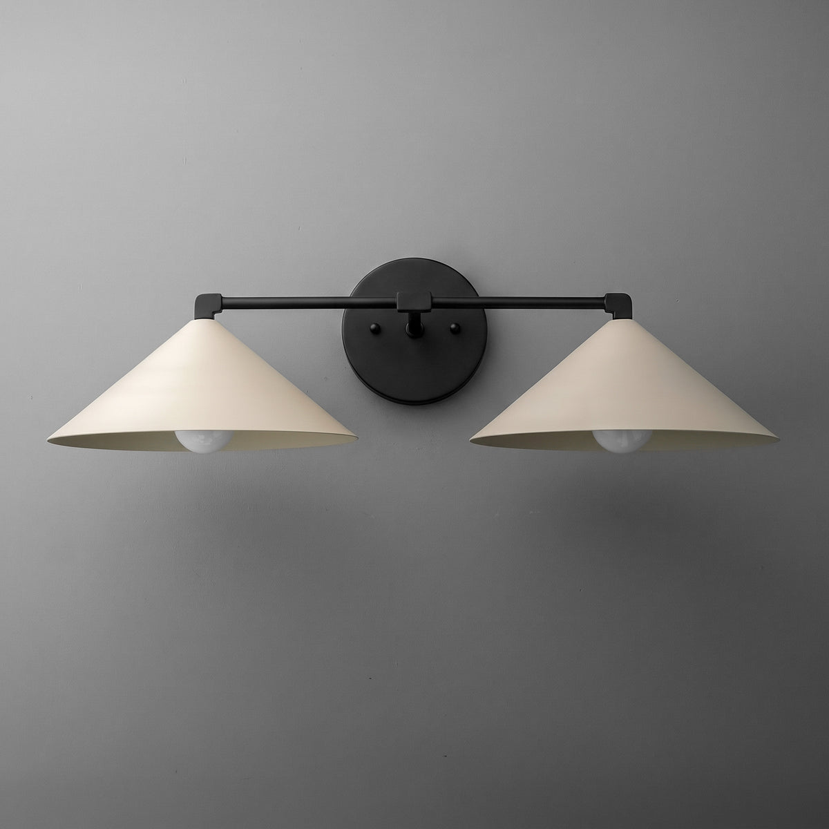 Two-light vanity light in Black with wide steel cone shades on a straight arm and a round wall plate. - VANITY LIGHT MODEL NO. 1185