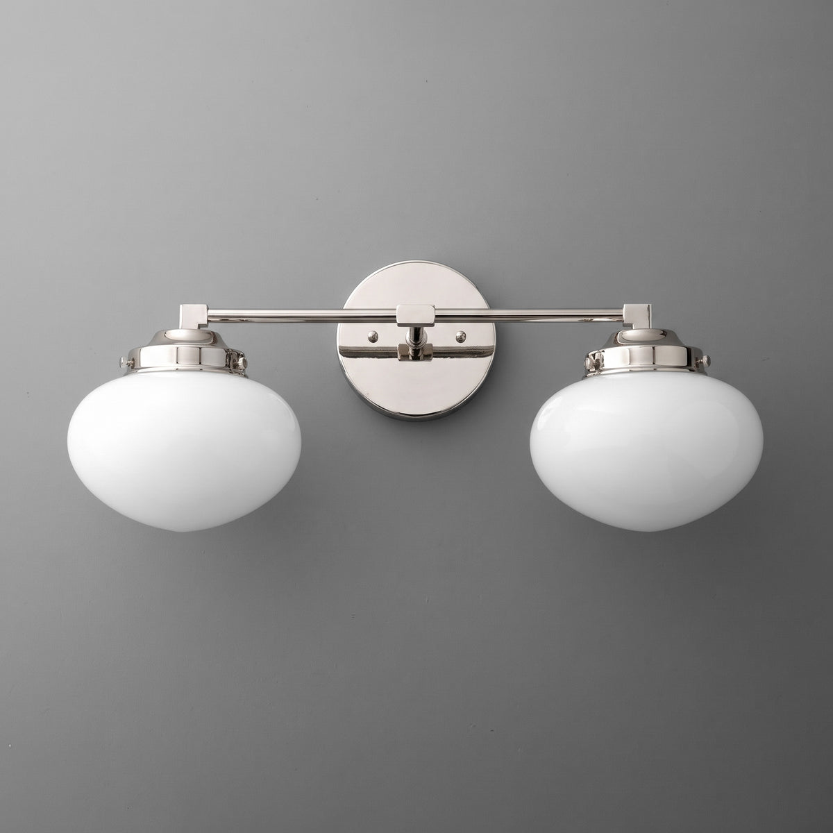 Brushed nickel two-bulb vanity light with smooth white glass oval shades and round wall mount. - VANITY LIGHT MODEL NO. 1167
