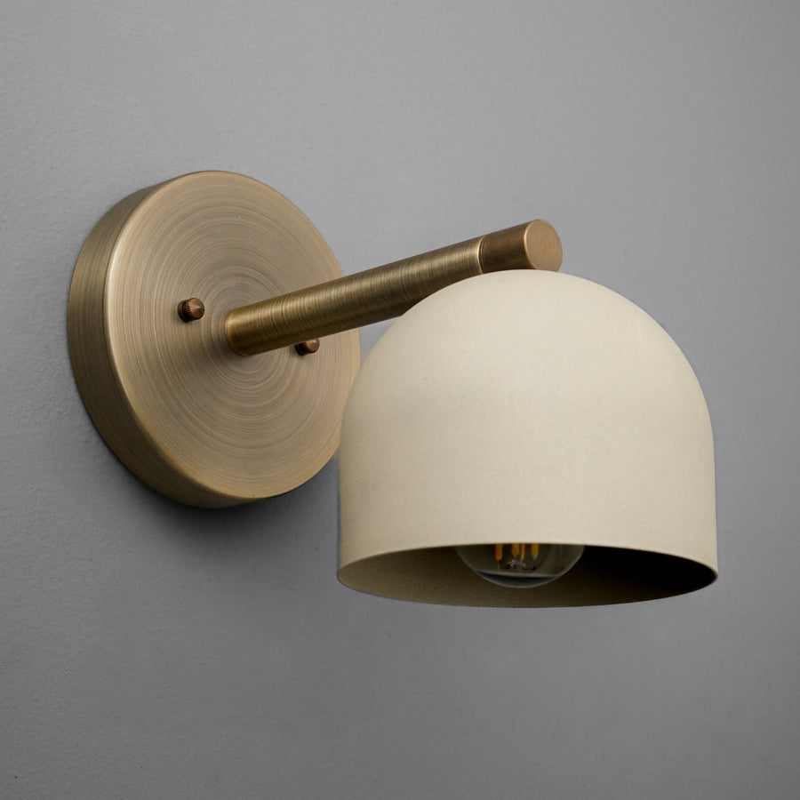 Wall sconce with antique brass finish and cream dome-shaped metal shade. - Sconce Model No. 5356