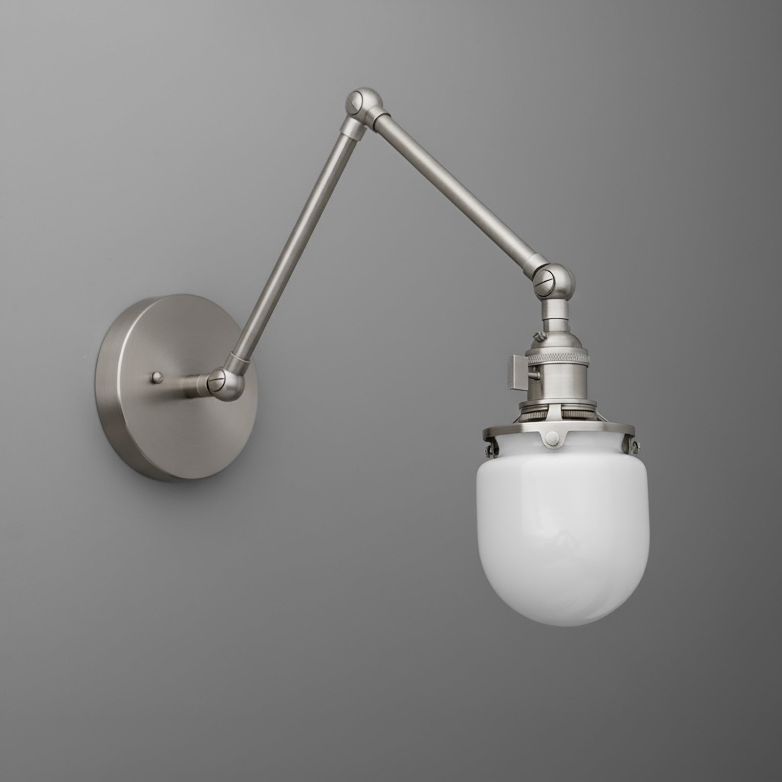 Adjustable brushed nickel wall sconce with a white frosted glass globe shade and industrial-style joints. - SCONCE MODEL NO. 7575