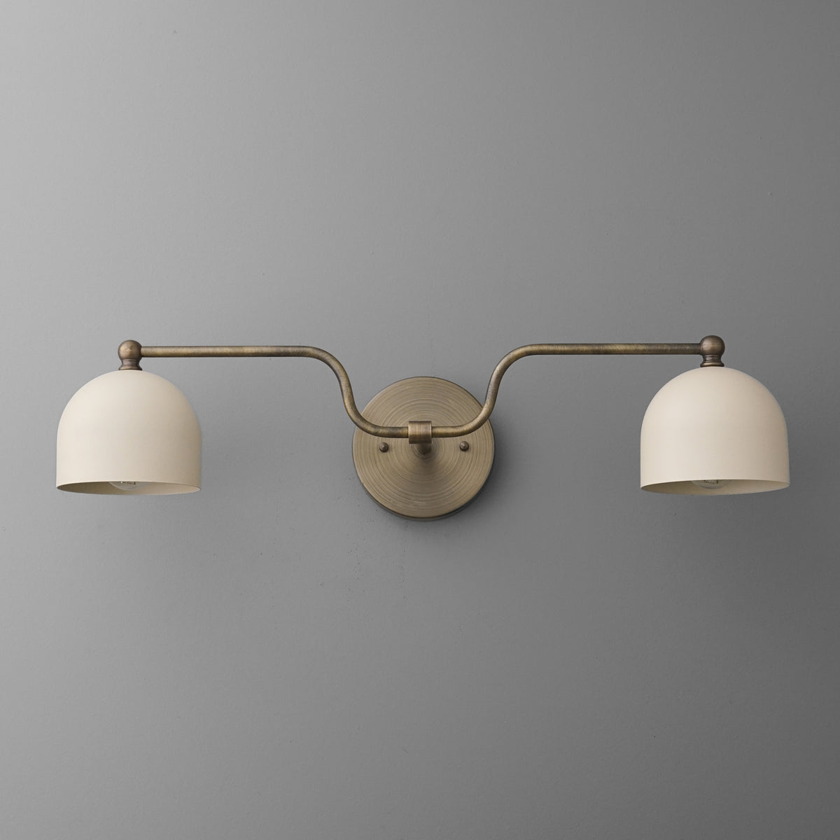 Brushed metal double-arm vanity light with two cream dome shades mounted on a round backplate. - VANITY LIGHT MODEL NO. 1157