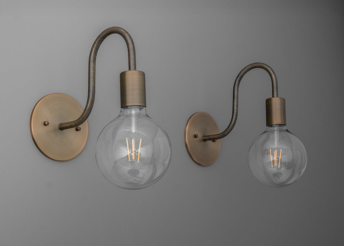 Pair of wall sconces with matte brass finish, curved arms, and exposed round filament bulbs. - SCONCE MODEL NO. 4753
