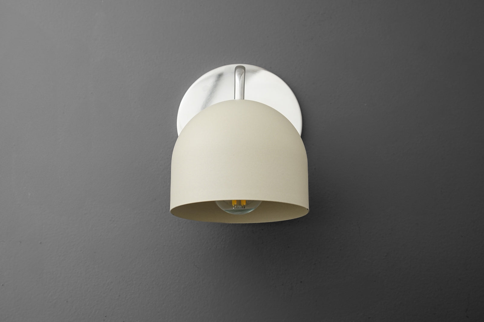 Wall sconce with polished nickel base and smooth cream dome shade against gray background. - SCONCE MODEL NO. 9436