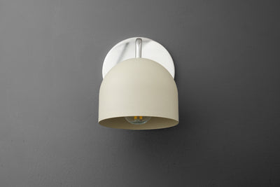 Wall sconce with polished nickel base and smooth cream dome shade against gray background. - SCONCE MODEL NO. 9436