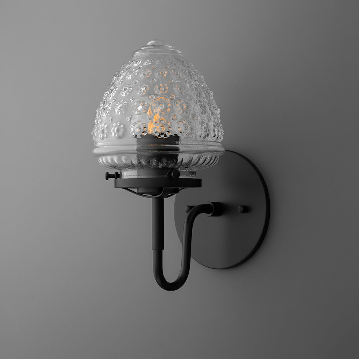 Wall-mounted black metal sconce with textured clear glass globe shade and single bulb. - SCONCE MODEL NO. 1037