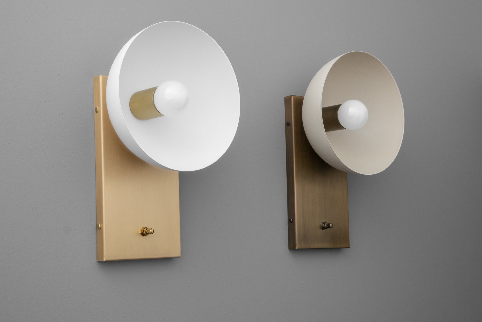 Pair of dome-shaped wall sconces with brass rectangular mountings and flared white and cream shades. - SCONCE MODEL NO. 3357