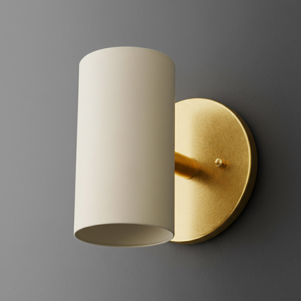 Cylinder sconce with a Cream shade on a short stem from a Raw or Sealed Brass round wall plate. - SCONCE MODEL NO. 9697