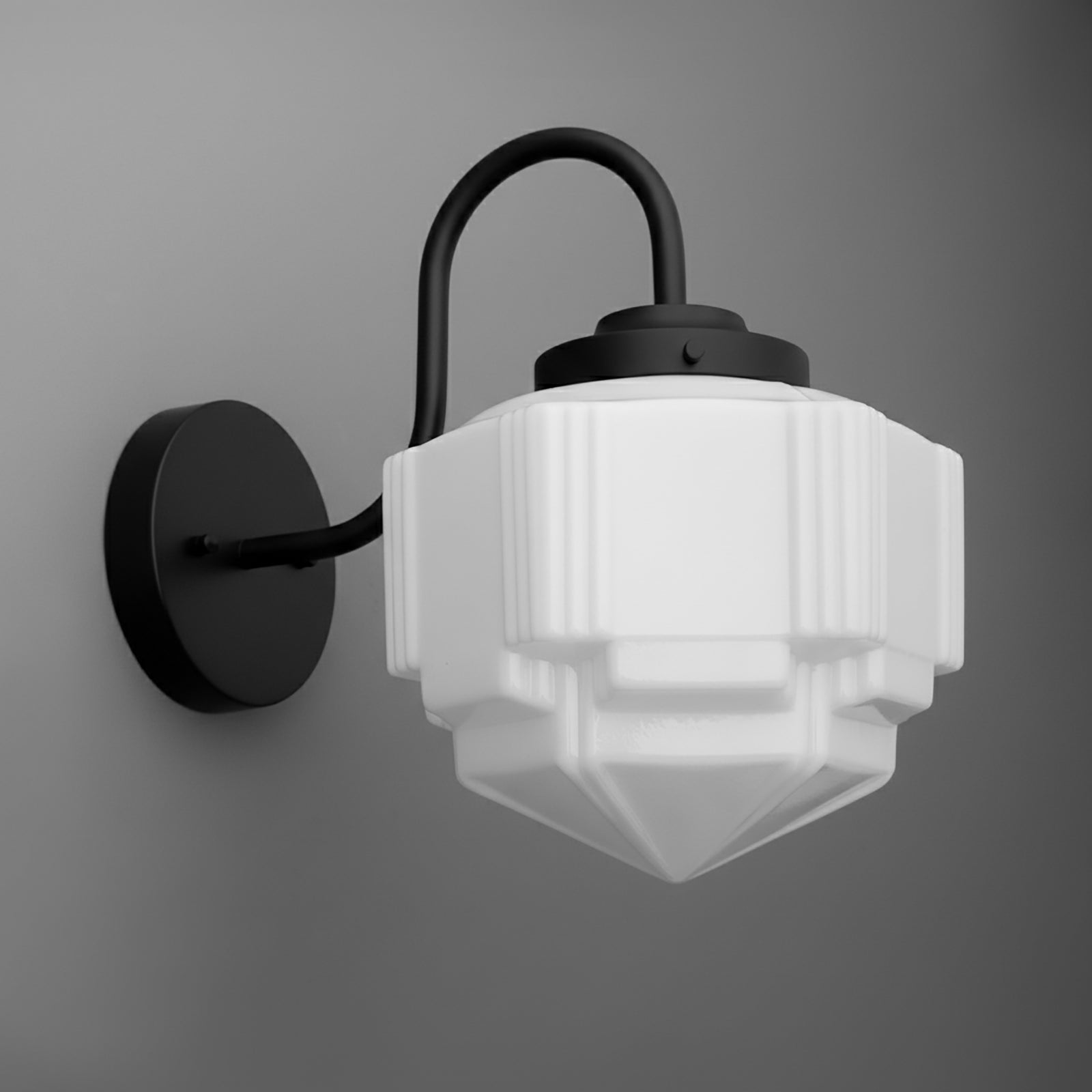 Black metal wall sconce with geometric frosted white glass shade and curved arm. - SCONCE MODEL NO. 1058