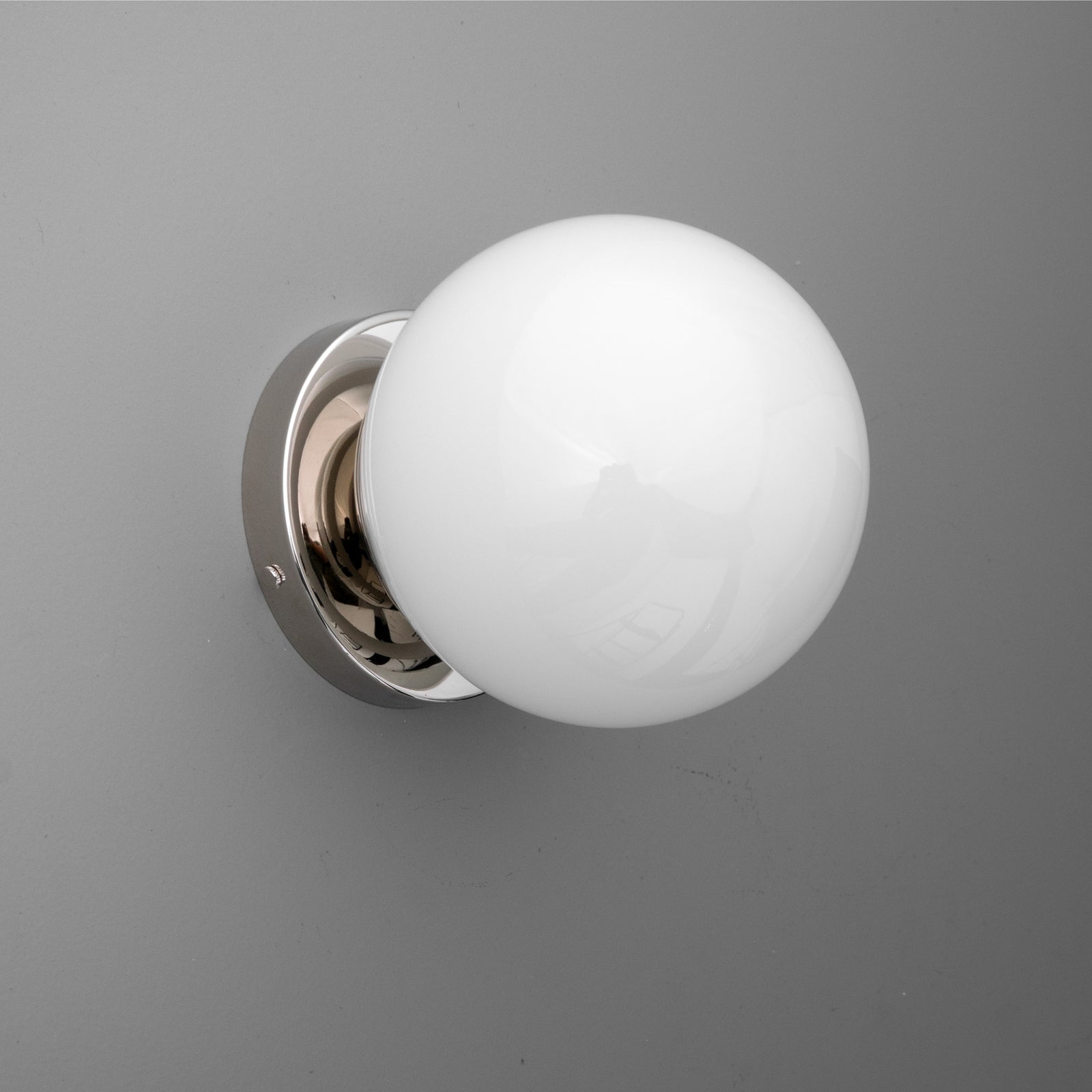 Wall-mounted sconce with a polished chrome base and a round white glass globe shade. - SCONCE MODEL NO. 3825