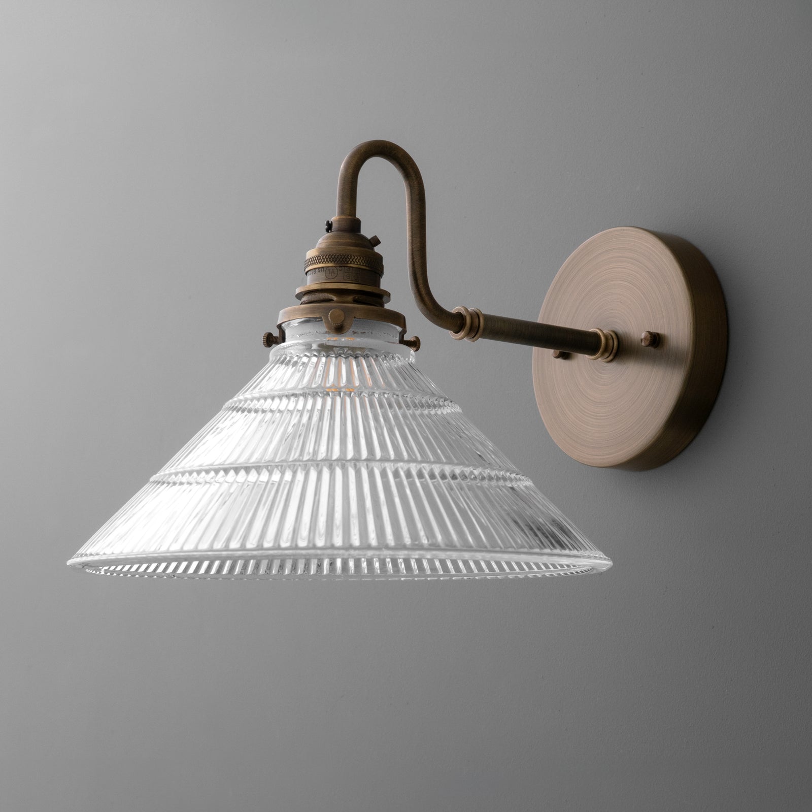 Wall-mounted sconce with brass finish arm and clear ribbed glass conical shade. - SCONCE MODEL NO. 4703