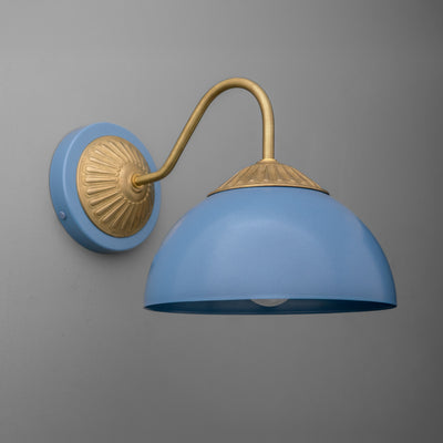 Raw brass sconce with a curved arm and periwinkle blue dome shade against a gray wall. - SCONCE MODEL NO. 9408