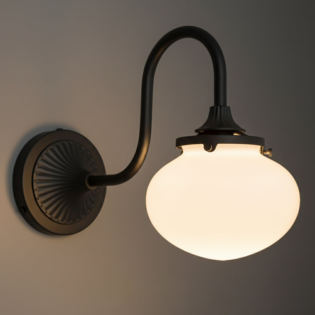 Sconce in Black with a gooseneck arm from a fluted fan wall plate, lit, with the opal glass bubble shade glowing warm. - SCONCE MODEL NO. 5310