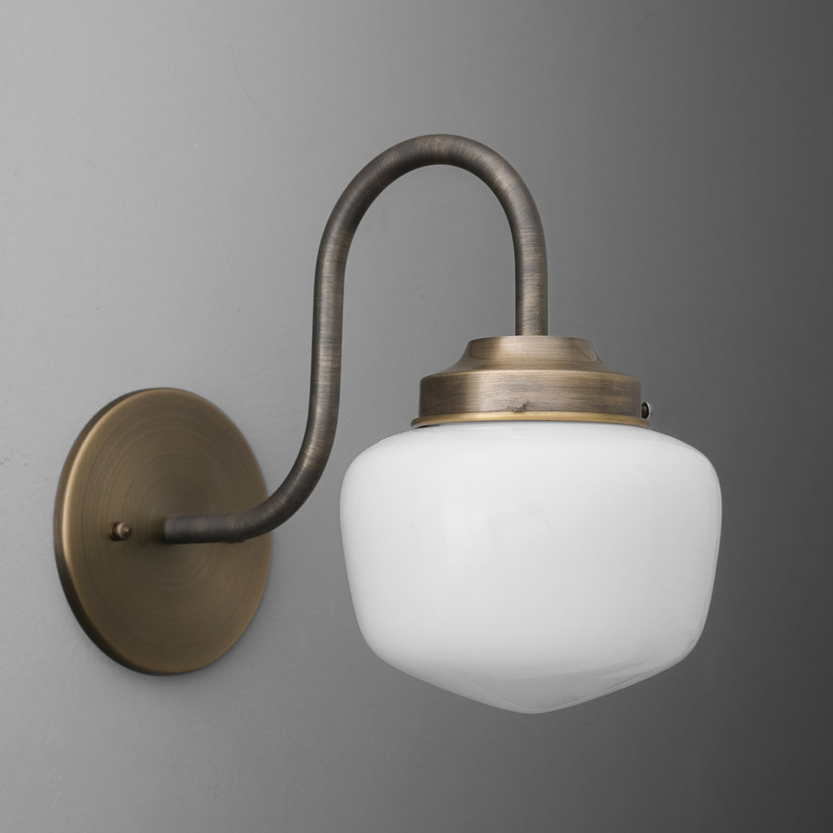Wall-mounted bronze sconce with curved arm and frosted white glass shade. - SCONCE MODEL NO. 1012